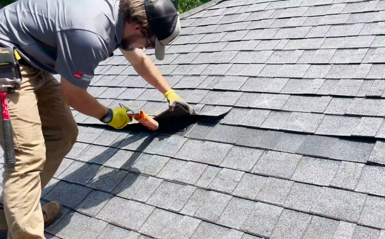 Professional roofer repairing asphalt shingles on residential property in Norwalk, CA
